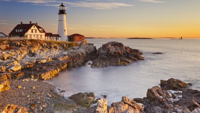 The Portland Head Lighthouse in Maine is shown at sunrise. Portland is a port of call on the Stitchers' Escapes 2023 fall needlework cruise.